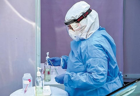 A technician of Dr Dangs Lab demonstrates before the media a sample collection process for COVID-19 tests in New Delhi on Monday | pti
