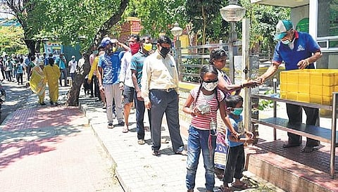 People form a queue while maintaining social distance to get food at an Indira Canteen in Bengaluru | VInod Kumar T