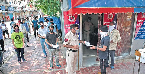 Delhi Police personnel check documents of migrant labourers before their registration to return home | shekhar yadav