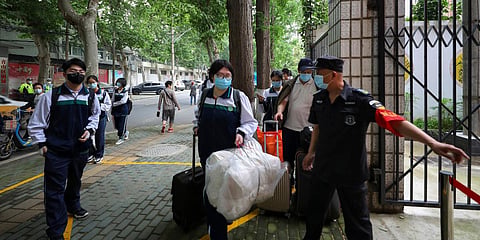 Students, wearing protective face masks to help curb the spread of the new coronavirus, arrive to a high school in Wuhan in central China's Hubei province. (File photo| AP)