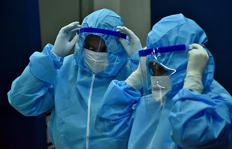 Healthcare workers getting ready by donning personal protective equipment PPE with face shields before Testing swabs through RT-PCR method in Coimbatore (Photo | U Rakesh Kumar/EPS)