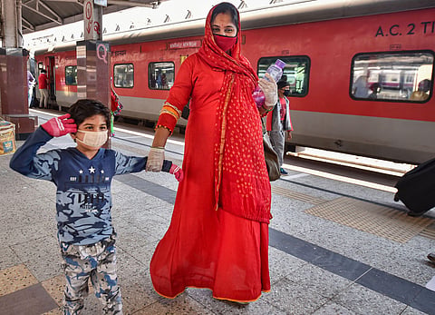 A pregnant woman along with her son walks to board a train for Delhi at Howrah Station following resumption of passenger train services connecting major cities during the ongoing COVID-19 nationwide lockdown in Kolkata Tuesday May 12 2020. (Photo | PTI)