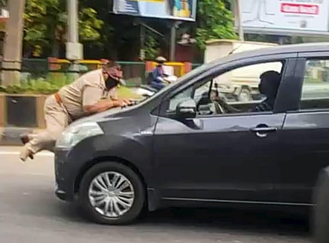 A car driver drags a police officer on car's bonnet in Jalandhar, after the officer tried to stop the vehicle. (Photo | PTI)