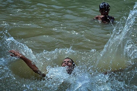 Boys take a dip in a canal to beat the heat on the outskirts of Amritsar. (Photo | PTI)