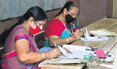 teachers evaluating papers. Image used for representation.