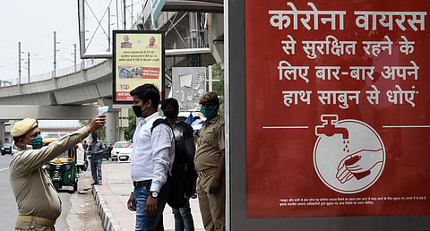 Delhi Home Guard personnel thermal screening people before they are allowed to board buses at Anand Vihar bus stop on May 29 2020 in New Delhi. (Photo | Parveen Negi/EPS)
