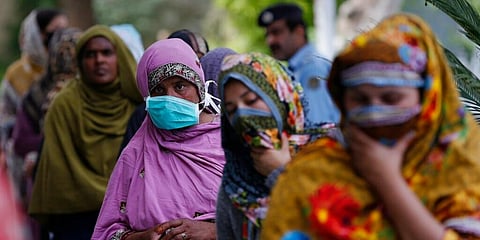 Pakistani women wait for their turn to receive aid during a government-imposed nationwide lockdown to help contain the spread of coronavirus. (Photo | AP)