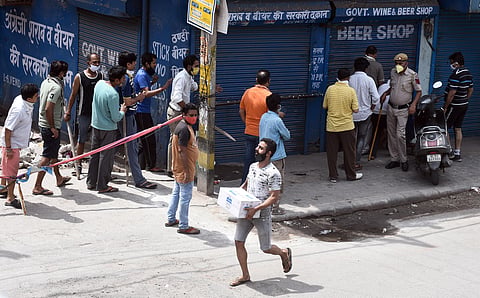 A customer carries alcohol after purchasing from a wine shop during the ongoing COVID-19 nationwide lockdown at Vishwas Nagar in East Delhi on Monday May 4 2020. (Photo | Parveen Negi/EPS)
