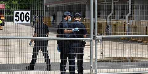 Police officers, wearing face mask enter the gate of a dormitory compound for foreign workers placed under quarantine to battle the spread of COVID-19 in Singapore. (File photo| AFP)