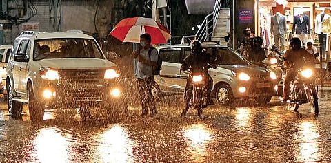 Commuters try to wade through sheets of water after showers lash the city on Wednesday | VINAY MADAPU