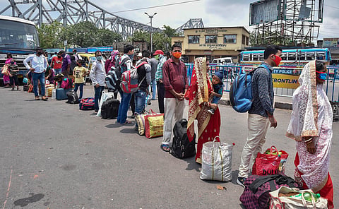 Migrants stand in a queue to board a bus to reach their native places during COVID-19 lockdown 5.0 outside Howrah station in Kolkata Monday June 1 2020. (Photo | PTI)