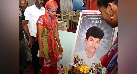 Kowsalya stands before a photo of her husband Shankar who was killed in broad daylight in Udamalapet. (Photo | Express)
