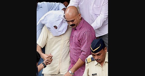 Sanjeev Khanna the former husband of Indrani Mukherjea arrested in connection with the Sheena Bora murder case is escorted out of Bandra Metropolitan Magistrate after he was produced in Mumbai on Friday. (File Photo | PTI)