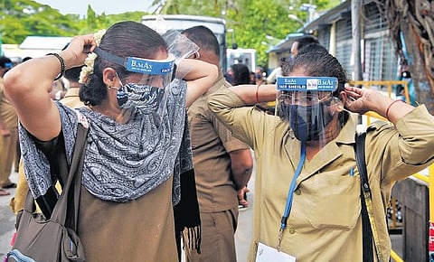 Two women BMTC bus conductors wear face shields distributed by Mrs India Karnataka team in Bengaluru on Friday | meghana Sastry