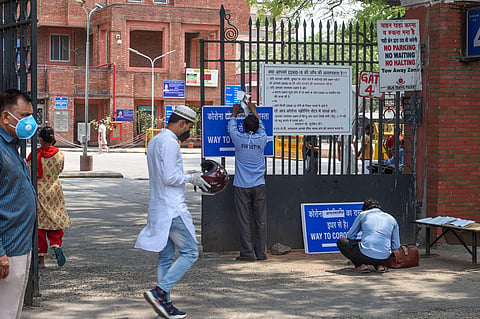 A worker hangs a notice on the main gate of LNJP Hospital during the ongoing COVID-19 lockdown in New Delhi Saturday June 6 2020. (Photo | PTI)