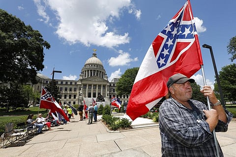In this Sunday, June 28, 2020, file photo, David Flynt of Hattiesburg, stands outside the state Capitol with other current Mississippi flag supporters. 'I love this flag,' Flynt said. Mississippi's Republican-controlled Legislature voted Sunday to remove