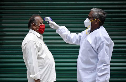 A Health Worker checking the temperature at the fever camp near Chepauk in Chennai on Saturday. (Photo | R Sathish Babu/EPS)