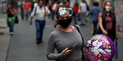 People walk down a street in central Mexico City after partial reopening of COVID-19 lockdown. (Photo| AP)