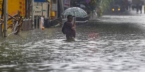 A man seen standing on a flooded road. (Photo | PTI)