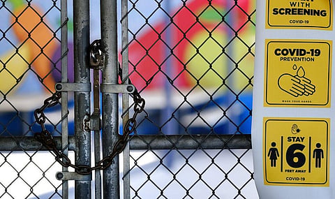 In this July 13, 2020, file photo, a chain-link fence lock is seen on a gate at a closed Ranchito Elementary School in the San Fernando Valley section of Los Angeles. California Gov. Gavin Newsom laid out strict criteria Friday, July 17, 2020, for school