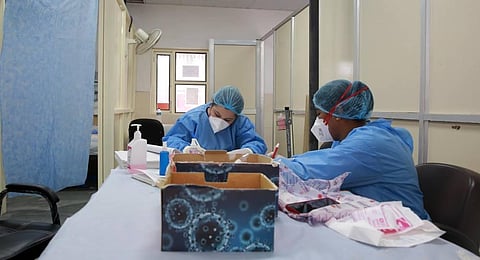 Health official labels rapid test kits at a Covid-19 rapid antigen testing Centre in New Delhi on Saturday. (Photo | Shekhar Yadav/EPS)