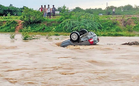 A car is dragged into swirling flood waters in Pagidirayi village of Kurnool district on Saturday | EXPRESS