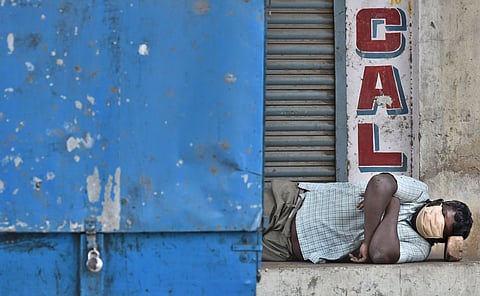 A man sleeps beside a locked streetside cart. (File Photo | P Jawahar, EPS)