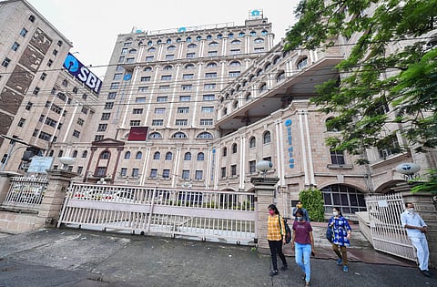 People wearing protective masks come out of the Samriddhi Bhawan the local head-office of the State Bank of India in Kolkata Tuessday July 7 2020. (Photo | PTI)