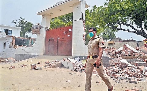 A policeman near the demolished house of gangster Vikas Dubey | FILE