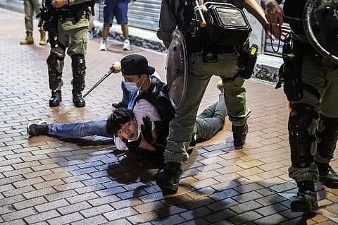 A pro-democracy demonstrator in Hong Kong is held on the ground before getting arrested. Protests against the national security bill had brought life to a standstill in Hong Kong for months in early 2019. (Photo | AFP)