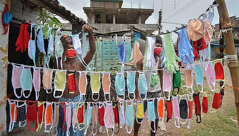Workers hang masks for drying at garments factory converted to manufacture protective masks amid the coronavirus pandemic. (Photo | PTI)