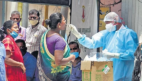 A health staff taking swab sample from a woman for testing at a camp set up in Madurai on Monday | kk sundar