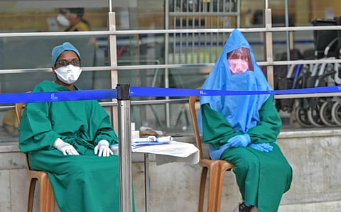 Doctors sit outside a hospital in Bengaluru to screen patients. (File Photo | Meghana Sastry, EPS)