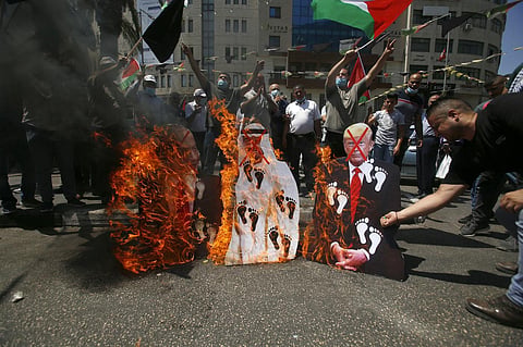Palestinians burn pictures of Donald Trump, Crown Prince Mohammed bin Zayed al-Nahyan and Benjamin Netanyahu during a protest against the UAE's deal with Israel. (Photo | AP)