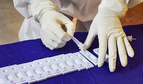 A medic wearing a PPE conducts COVID-19 rapid antigen testing. (Photo | PTI)