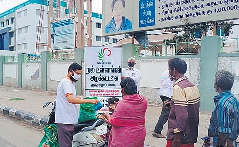 Alumni of Jamal Mohamed College distributing food near Mahatma Gandhi Memorial Government Hospital on Sunday in Tiruchy. (Photo | EPS)