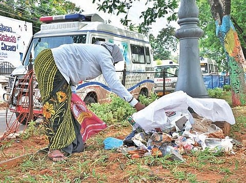 A heap of used PPE kits, masks and gloves thrown at a walking track just outside the State Covid Hospital in Vijayawada on Monday (Photo | Prasant Madugula, EPS)