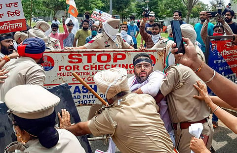 Punjab Police try to stop workers of the Bharatiya Janata Yuva Morcha who were marching towards the residence of MLA Navjot Singh Sidhu during a protest over the hooch tragedy. (Photo | PTI)