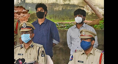 West Zone DCP AR Srinivas addresses the media, while the accused — Devaraj Reddy and Sai Krishna Reddy, stand behind him, in Hyderabad. (Photo | RVK Rao, EPS)