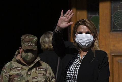 Bolivia's interim President Jeanine Anez, wearing a face mask to help curb the spread of the new coronavirus, waves during a procession Corpus Christi, in La Paz, Bolivia, Thursday, June 11, 2020. (Ph