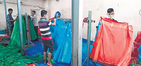 Workers ready the Bathukamma sarees that are to be distributed this year, at a handloom unit in Rajanna-Sircilla district on Thursday. With manufacturing processes over, the workers are now busy fold