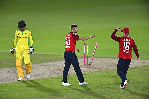 England's Mark Wood, center, celebrates with captain Eoin Morgan, right, the dismissal of Australia's Alex Carey, left, during the first Twenty20 cricket match.(Photo | AP)