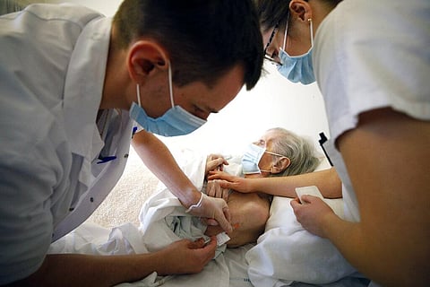 In this Jan. 6, 2021, file photo, Dr. Cedric Waechter, left, administers the Pfizer-BioNTech COVID-19 vaccine to a resident of the Bois Fleuris nursing home. (Photo | AP)