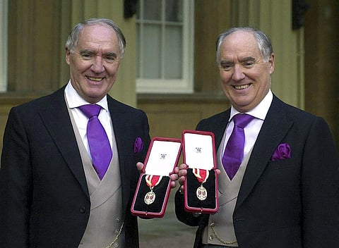 Multi-millionaires David Barclay, left, standing with his twin brother Frederick Barclay, after receiving their knighthoods from the Queen. (File photo | AP)