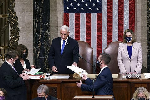 Vice President Mike Pence hands the West Virginia certification to staff as Speaker of the House Nancy Pelosi, D-Calif., listens. (Photo | AP)