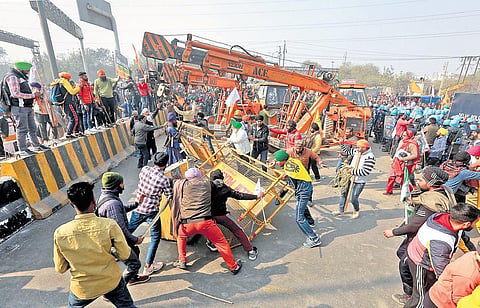 Farmers and their supporters remove barricades during the tractor rally near Sanjay Gandhi Transport Nagar in New Delhi. (Photo | Shekhar Yadav, EPS)