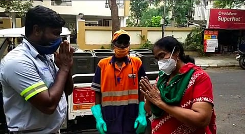 M Moorthy (in reflective jacket), battery operated vehicle driver for Urbaser, along with Selvam K, supervisor, returning the foreign currency to Mary Chitra, a Mylapore resident. (Photo | Express)