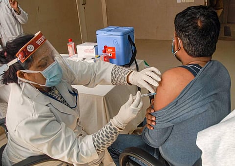 A medic administers the dose of COVID-19 vaccine on a beneficiary during the vaccination drive across the country at a district hospital in Noida. (Photo | PTI)
