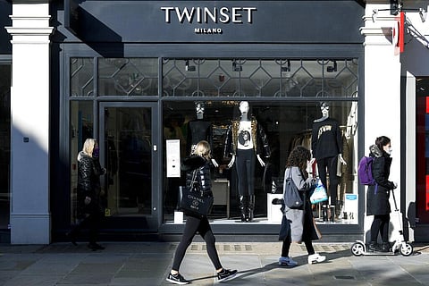 People walk past a retail shop in England. (Photo | AP)