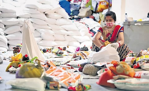 A volunteer at the Goonj processing unit in Sarita Vihar, sorting out the collections received as part of the Odha Do Zindagi initiative